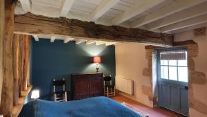 a bedroom with a blue bed and a window at Magnifique ferme landaise 12 couchages in Allons