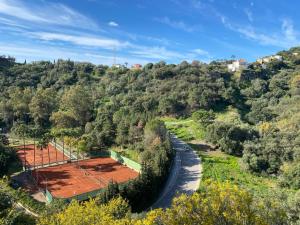 een luchtzicht op een tennisbaan op een heuvel bij Hidden Gem Bed& Breakfast Estepona Hills in Estepona