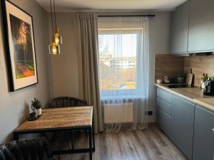 uma cozinha com uma mesa de jantar e uma janela em City chic rental em Valmiera