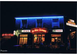 a blue building with neon signs on it at night at Le Clos Normand in Troarn