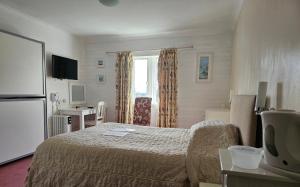 um quarto de hotel com uma cama e uma janela em Schoolhouse Restaurant and Hotel em Swindon