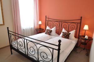 ein Schlafzimmer mit einem großen Bett mit weißer Bettwäsche und Kissen in der Unterkunft Hotel Grader in Neustadt an der Waldnaab