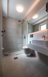 a bathroom with a shower and a toilet and a sink at Sappho Studios in Mytilene