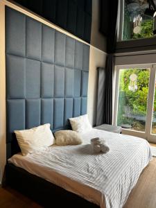 a large bed with a blue headboard in a bedroom at Appartment Pruhonice & terrace in Pruhonice