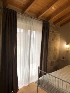 ein Schlafzimmer mit einem Bett und einem großen Fenster in der Unterkunft Covo Residence - Casa Manhusca 