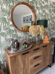 een spiegel bovenop een dressoir in een kamer bij Tiny romantic cottage for two. in Lostwithiel