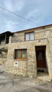 um edifício de pedra com uma porta castanha e janelas em Covo Residence - Casa Manhusca 