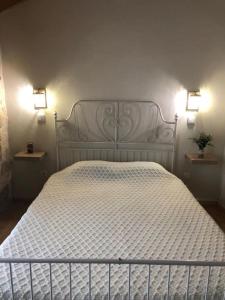 a bedroom with a white bed with two lights on the wall at Covo Residence - Casa Manhusca 