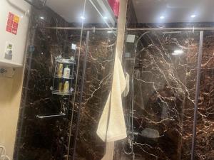 a bathroom with a shower with black marble at App Alya Casablanca in Casablanca