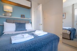 a bedroom with a blue bed with towels on it at Cosy, bright apartment moments from the sea! in Brighton & Hove