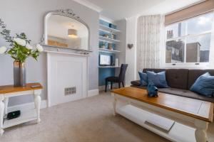 a living room with a couch and a table at Cosy, bright apartment moments from the sea! in Brighton & Hove