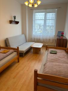 米洛維采的住宿－Apartmán Esser 3，客房设有两张床、一张桌子和一扇窗户。
