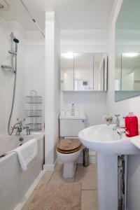 a white bathroom with a toilet and a sink at Cosy, bright apartment moments from the sea! in Brighton & Hove