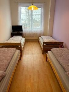 a room with three beds and a window at Apartmán Esser 3 in Milovice