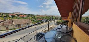 a balcony with a table and a view of a street at Pensiunea Maria in Cerna