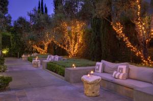 un jardin éclairé avec un canapé et des bougies dans l'établissement Luxe Sunset Boulevard Hotel, à Los Angeles