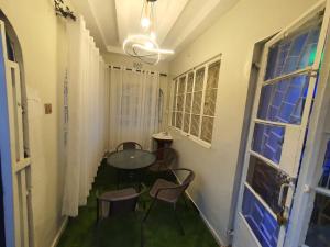 a room with a table and chairs and a window at Greenstar home in Kisii