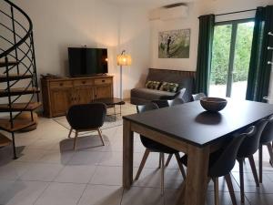 ein Wohnzimmer mit einem Tisch und Stühlen in der Unterkunft Gîte des Pins-Chambord-Beauval in Cheverny