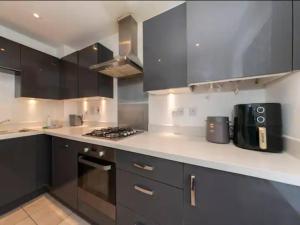 a kitchen with black cabinets and a counter top at Pass the Keys Semi-detached house with garden and free parking in Shinfield
