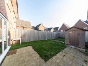 a backyard with a wooden fence and a yard at Pass the Keys Semi-detached house with garden and free parking in Shinfield