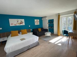 ヴェゾン・ラ・ロメーヌにあるHôtel La Bastide de Vaisonの青い壁のベッドルーム1室(大型ベッド1台付)