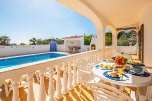 a villa with a swimming pool and a table with food at Villa Renaissance by Algarve Vacation in Carvoeiro