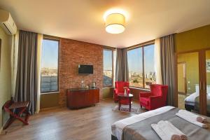 ein Hotelzimmer mit einem Bett und einem großen Fenster in der Unterkunft Kraveli Hotel in Tbilisi City