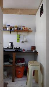 - une cuisine avec des étagères et un tabouret dans une pièce dans l'établissement White Moon Men's Hostel, à Dubaï