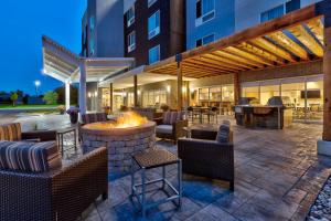 um pátio exterior com uma fogueira, mesas e cadeiras em TownePlace Suites by Marriott Grand Rapids Airport Southeast em Grand Rapids