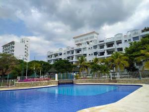 uma grande piscina azul em frente a um edifício em Balcones de Costa Azul Apto 302 em Santa Marta