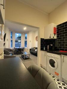 a kitchen and living room with a washing machine at Guest House 5 Beds 4 En-suites Middlesbrough in Middlesbrough