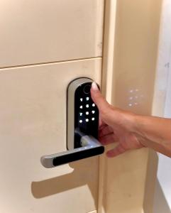 a hand is unlocking a drawer with a remote control at Apartamento centrico con vistas panoramicas Puerto Iguazu in Puerto Iguazú