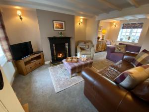 a living room with a couch and a fireplace at 5* Family Holiday Home in the Yorkshire Wolds in Huggate