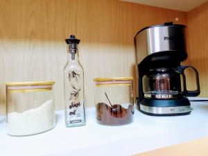 a kitchen counter with a coffee maker and a bottle at Studio Luxo, em Anápolis - Perfeito in Anápolis