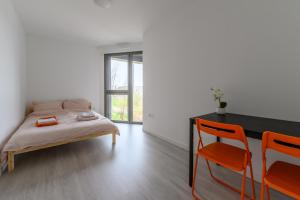a bedroom with a bed and a table and chairs at Le Duplex de Bougainville - Appt à 30min de Paris in Noisy-le-Grand