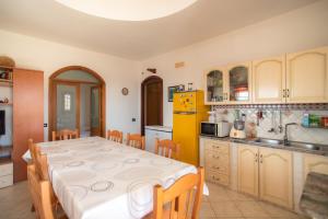 a kitchen with a table and a yellow refrigerator at Dammuso Ignazio in Lampedusa