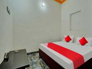 Un dormitorio con una cama roja y blanca y un escritorio. en OYO Home Hotel White Town en Bhilai