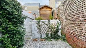 an alley with a brick wall and stairs next to a building at Maison Ma Bohème, 250m de la mer in Cayeux-sur-Mer