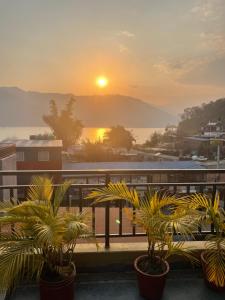 een uitzicht op de zonsondergang vanaf een balkon met planten bij Hotel My Dream in Pokhara