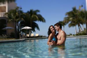Ein Mann und eine Frau sitzen im Pool in der Unterkunft Beachside Resort & Residences in Key West