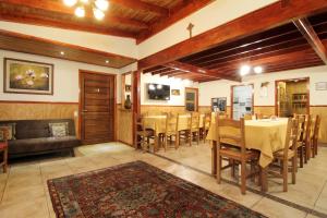 a dining room with a table and chairs and a couch at Apart Hotel Villa Los Ciruelos in Valdivia