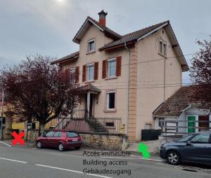a house with two cars parked in front of it at Le Coquelicot : appartement T1 in Héricourt