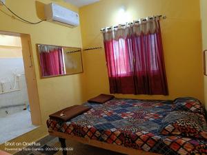 a bedroom with a bed and a bath room at Vicky's Home Stay Hampi in Hampi