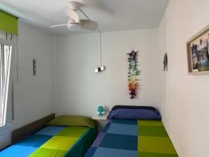 two beds in a room with colorful floors at Apartamento con vistas al mar in Cambrils