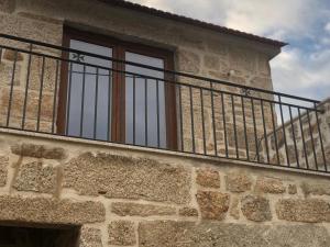 a balcony on the side of a building with a window at Covo Residence - Casa Santiago in Vila Nova de Paiva