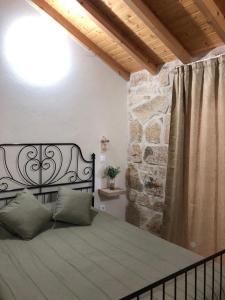 Cama en habitación con pared de piedra en Covo Residence - Casa Santiago, en Vila Nova de Paiva