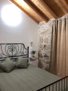 a bed in a room with a stone wall at Covo Residence - Casa Santiago in Vila Nova de Paiva