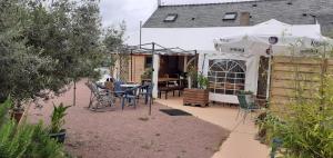 een patio met een parasol en een tafel en stoelen bij Cafe de la croix morzel in Cordemais