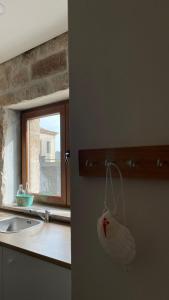 a kitchen with a sink and a bag hanging from a door at Covo Residence - Casa Santiago in Vila Nova de Paiva