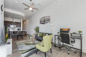 sala de estar con sofá, mesa y TV en Chic loft style 2BR I Gym I Parking I Workspace en Dallas